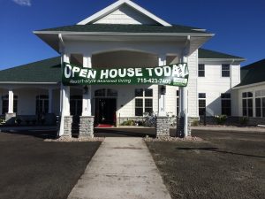 A large banner alerts passers-by that Hilltop Grand Village is having an open house.